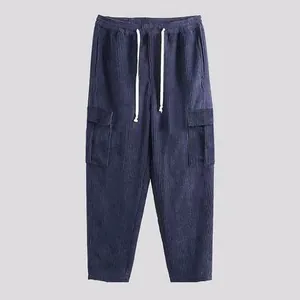 Dettaglio dei pantaloni cargo in velluto a coste blu con coulisse in vita e gamba dritta