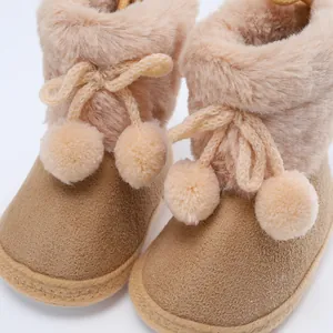 Detailaufnahme warmer Babystiefel mit weichem Kunstpelzfutter und niedlichen Bommeln