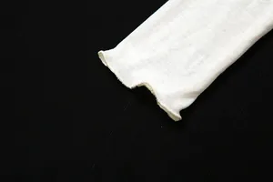 Close-up of sheer white long-sleeved T-shirt with ruffled lettuce edge cuff detail.
