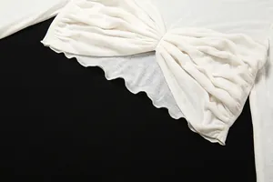 Detail view of a white cropped long-sleeve T-shirt with front pleats and wavy hem.