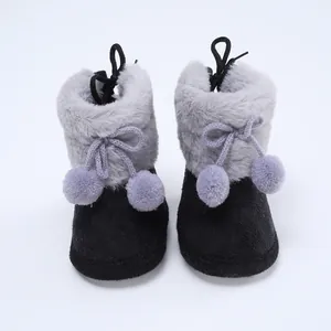 Gemütliche Baby-Winterstiefel mit grauem Kunstfellbesatz und niedlichen Pompons.