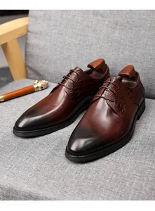 Vue détaillée de chaussures Derby en cuir marron avec gaufrage crocodile sur un canapé