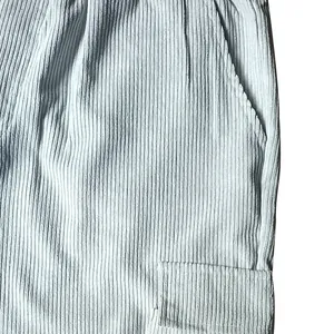 Dettaglio ravvicinato del tessuto in velluto a coste azzurro e tasca cargo di pantaloni casual