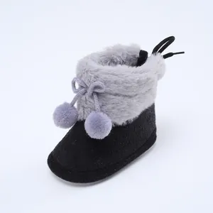 Detailaufnahme der kuscheligen Baby-Winterstiefel mit weichem Kunstfell und Bommeln