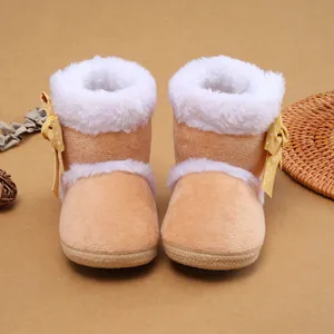 Detailansicht niedlicher Baby-Winterstiefel mit Pelzbesatz und gelben Schleifenakzenten