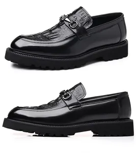 Vista lateral de mocasines negros para hombre con patrón de cocodrilo grabado y suela dentada