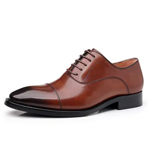 Classic brown leather Oxford dress shoes for men with cap-toe design on white background