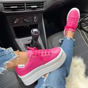 Detailaufnahme pinker Damen-Plateau-Sneaker mit dicker weißer Sohle im Fahrzeuginnenraum.