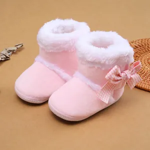 Nahaufnahme weicher rosa Babystiefel mit weißem Plüschfutter und karierter Schleife