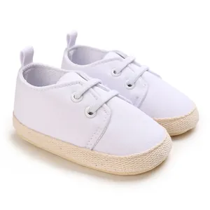 Nahaufnahme der weißen Baby-Leinenschuhe mit Strohsohle und weichem Futter für Kleinkinder.