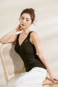 Close-up of a black thermal camisole with built-in pads shown on a model in sunlight.