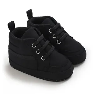Vue détaillée de baskets en toile noire pour nourrissons avec semelles très souples