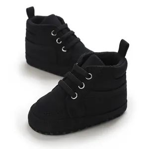 Gros plan de baskets pour bébé en toile noire avec semelles souples et lacets