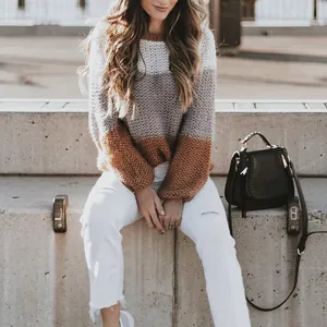 Chunky knit sweater featuring white, grey, and brown color-block stripes on a model