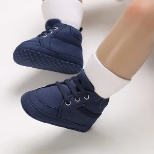 Vue détaillée de chaussures de marche montantes en toile bleu marine pour bébé avec semelles.