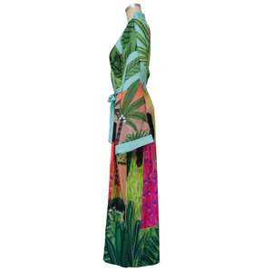 Vista laterale di un kimono a stampa tropicale con maniche larghe e cintura in vita.