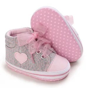 Dettaglio di scarpe neonato con pois rosa e cuore, suola morbida per bimbi 0-1 anni