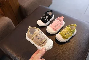 Detalle de zapatos de lona transpirables para bebés en colores caqui y rosa