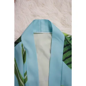 Primo piano del colletto di un kimono celeste con stampa di foglie tropicali verdi