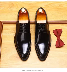Detail view of elegant black polished leather men's derby shoes on wood background