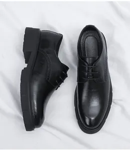 Detail view of black men's formal dress shoes with textured leather and thick soles