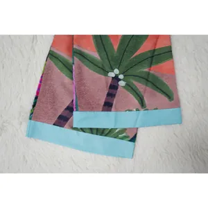 Dettaglio ravvicinato della stampa tropicale con palme e bordo blu di questo kimono