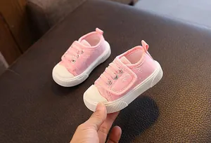 Detalle de zapatos de lona rosa para niños pequeños con suelas blancas antideslizantes