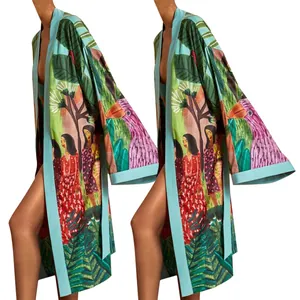 Dettaglio di una giacca kimono con stampa tropicale, uccelli vivaci e motivi di foglie esotiche.