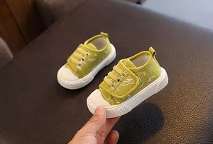 Primer plano de zapatos de lona verdes para niños con patrones blancos y suelas