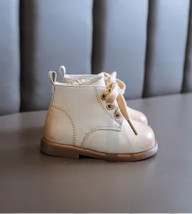 Side detail of beige leather baby boots with soft brown rubber sole