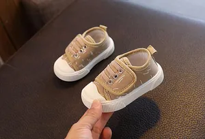 Detalle de zapatos de lona caqui para niños pequeños con cierre de velcro