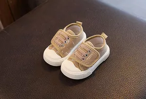 Vista superior de zapatos de lona beige transpirables para bebés con suela de goma blanca.