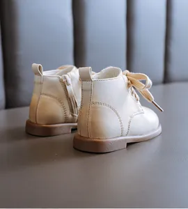 Rear side view of cream toddler British style soft sole boots with zipper and laces