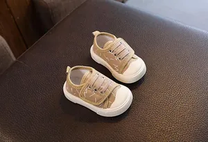 Primer plano de zapatos de lona caqui transpirables para bebés con suela antideslizante.
