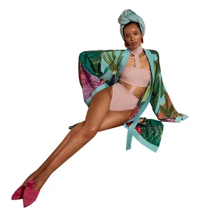 Elegante vestaglia kimono con stampa tropicale e body rosa su sfondo bianco puro