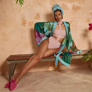 Copricostume kimono a stampa tropicale su costume rosa con cut-out su panca
