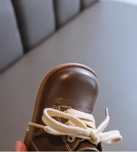Close-up detail showing the texture of brown leather toddler boot with fine stitching