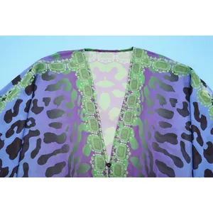 Detailaufnahme einer Chiffon-Bluse mit V-Ausschnitt und lila-grünem Leopardenmuster.