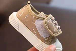 Detalle de zapato de lona caqui transpirable para bebé con cierre de velcro ajustable