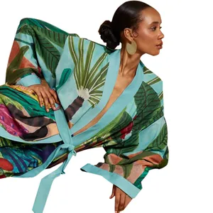 Dettaglio ravvicinato di una vestaglia kimono a stampa tropicale su una modella.