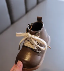 Detail view of the brown soft leather toddler boot with white stitching