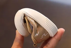 Primer plano de la flexibilidad de la suela de goma en un zapato de lona para niños