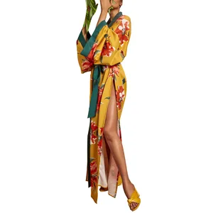Vista laterale della giacca kimono gialla floreale con spacco alto e fascia verde.