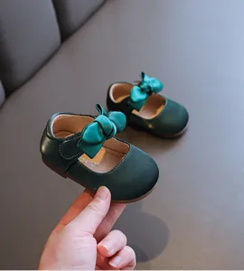 Elegante dunkelgrüne Baby-Mary-Janes mit großer Satinschleife und weichen Sohlen.