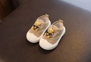 Khaki Baby-Segeltuchschuhe mit niedlichen Zeichentrickbären und weicher Sohle im Detail.