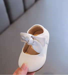Detailansicht der weichen cremefarbenen Lederschuhe mit dekorativer Schleife für Babys.
