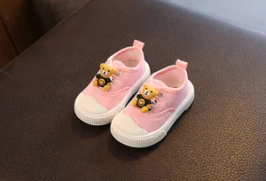 Nahaufnahme von rosa Baby-Leinenschuhen mit süßem Bären-Design und weicher Sohle
