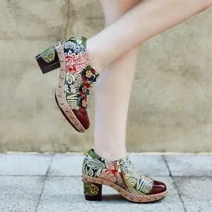 Close-up of retro floral leather high heels with 3D flower details on a model.