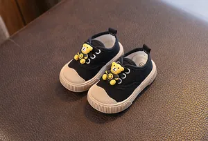 Nahaufnahme von Baby-Leinenschuhen mit süßem 3D-Bären und Smiley-Gesicht-Details.