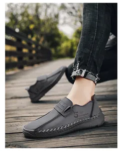 Gedetailleerd beeld van grijze casual herenloafers van leer op een houten wandelpad